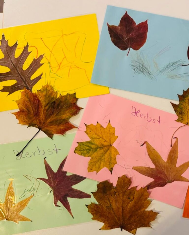 Bunte Kinderbastelbilder mit echten Herbstblättern und Zeichnungen auf farbigem Papier aus der Großtagespflege Rappelkiste Hochdahl.
